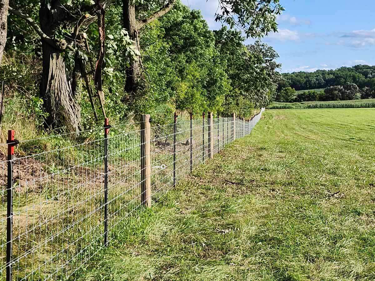 Fence with Woven wire fence installed around a farm field in Madison Wisconsin in Madison Wisconsin