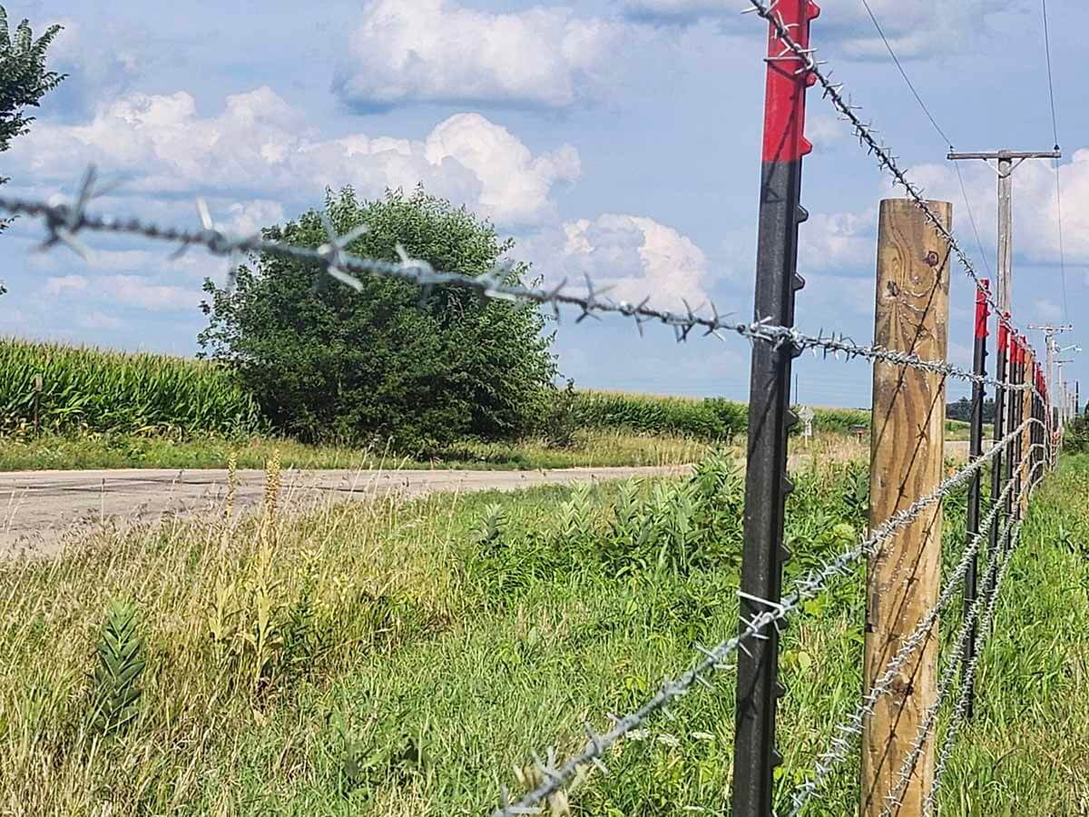 Fence with Barbed wire fence installed around a farm property in Madison Wisconsin in Madison Wisconsin