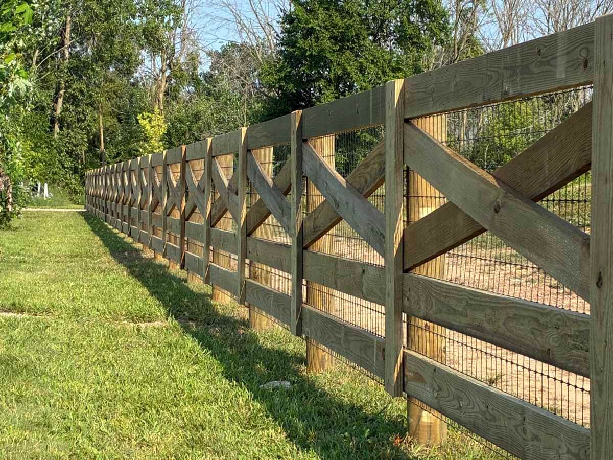 Fence with Crossbuck wood fence installed around a field in Madison Wisconsin in Madison Wisconsin